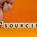 Word blocks spelling out 'outsourcing' being changed to 'insourcing'