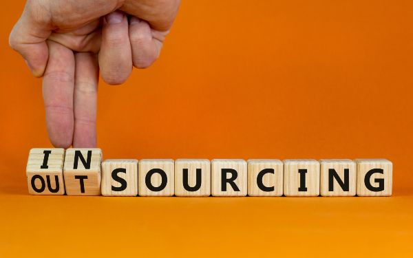 Word blocks spelling out 'outsourcing' being changed to 'insourcing'