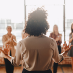 A team manager talking to practitioners with her back turned to the camera.