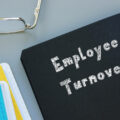 Black file on a desk with the words 'employee turnover' written on it