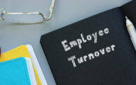 Black file on a desk with the words 'employee turnover' written on it