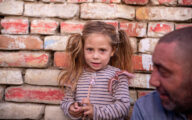 Picture of girl and her dad in front of a wall
