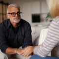 A woman and man holding hands, giving each other support