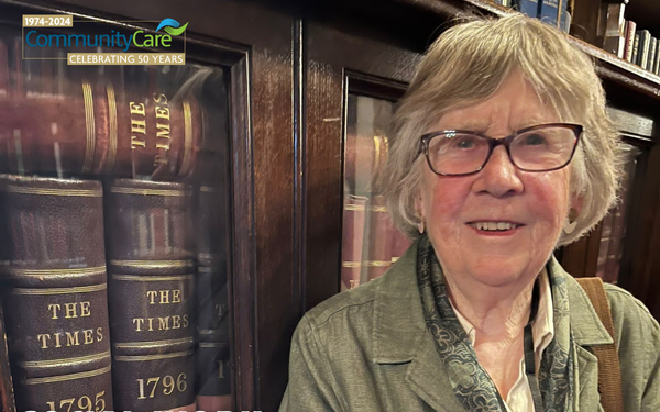 June Thoburn leaning against archives of the times from the 1700s