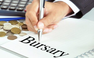 Hand with pen pointing to Bursary word on the paper - financial concept