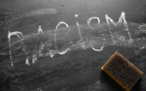 The word racism written on a chalkboard, half-erased.