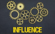 The word influence in yellow below a series of cogs against a black background