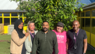 a group of social workers looking at the camera in front of a green background