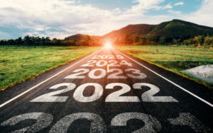 A road surrounded by fields heading into the distance with markings of the years 2021 2022 2023 2024 2025 on i