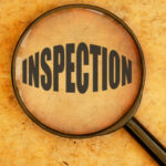 Magnifying glass focusing on the word inspection