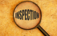 Magnifying glass focusing on the word inspection