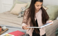 A teenage girl looks at a photo book at Christmas.