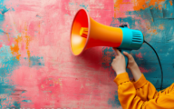 An orange and blue megaphone against a colourful, pink and blue, backdrop.