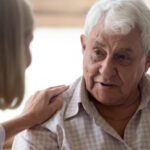 Social worker comforting older man