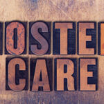 The words Foster Care concept and theme written in vintage wooden letterpress type on a grunge background.