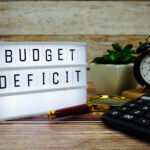BUDGET DEFICIT letterboard text on LED Lightbox on wooden background