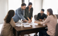 A group of colleagues discussing statistics in a meeting