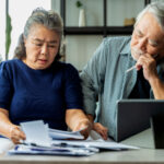 Older couple looking stressed when looking at bills