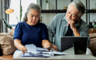 Older couple looking stressed when looking at bills