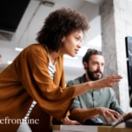 Female manager talking to male direct report about work in an office