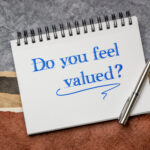 A note pad with 'do you feel valued?' written on the front