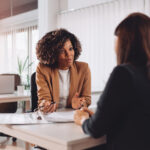 One woman interviewing another for a job in an office