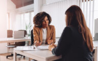 One woman interviewing another for a job in an office