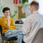 A female social worker speaking to a young man