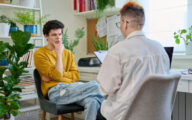 A female social worker speaking to a young man