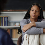 Teenage girl looking at therapist in therapy session