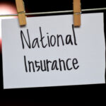 The words 'national insurance' written on a piece of paper pegged to a clothes line