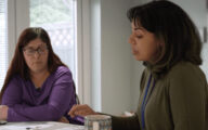 A social worker talking to a parent at a dinner table