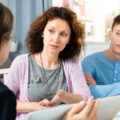 Woman and son having intense discussion with a social worker