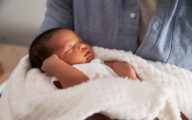 Newborn baby being held by father