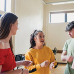 Four young people in animated discussion in a classroom