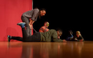 A group of four actors doing a theatre performance while wearing masks